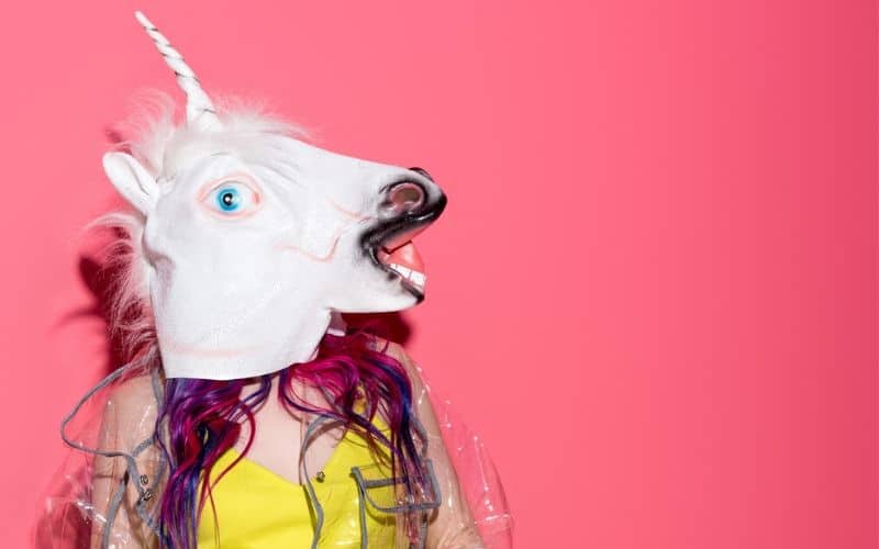 Woman in a unicorn head mask illustrating how to overcome the fear of failure.