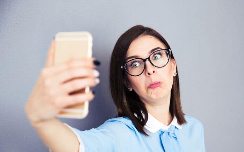 Woman making a sad face taking a selfie, illustrating how failure can lead to success in a funny way.